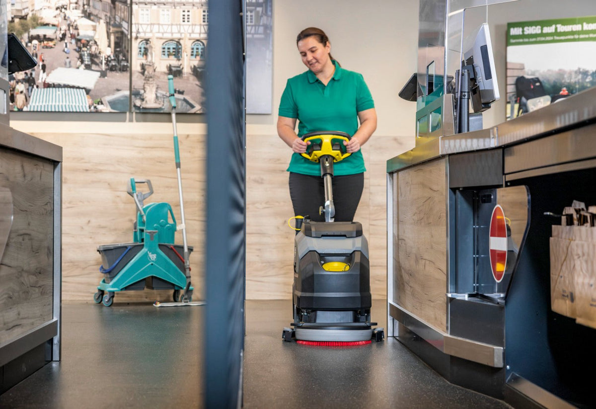 Person operating a floor cleaning machine in a retail setting